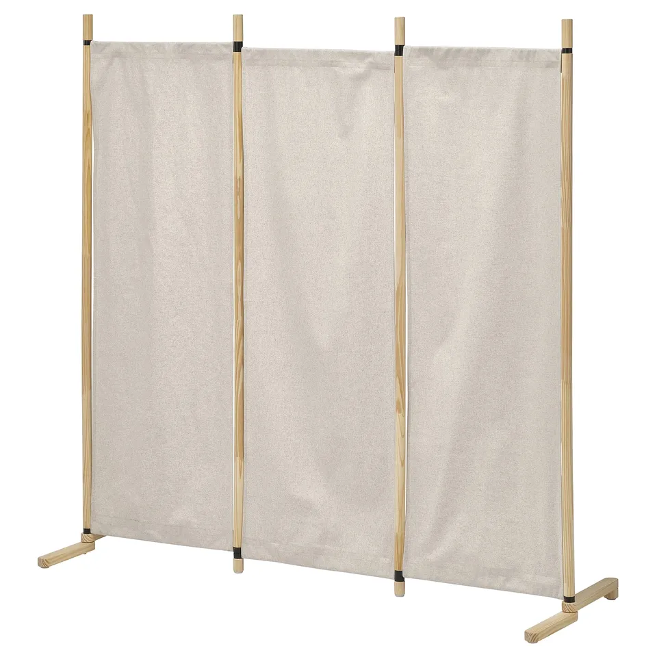 A beigecolored GLAMBERGET room divider with wooden poles, creating separate spaces.