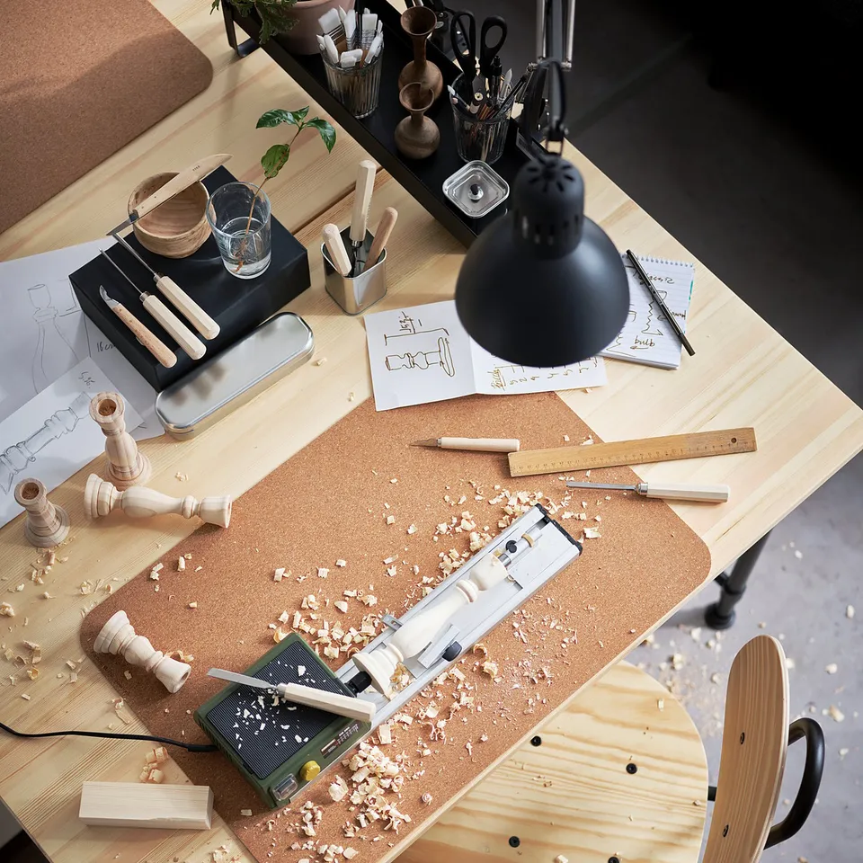 Wooden KULLABERG desk with tools, lamp, and crafts.