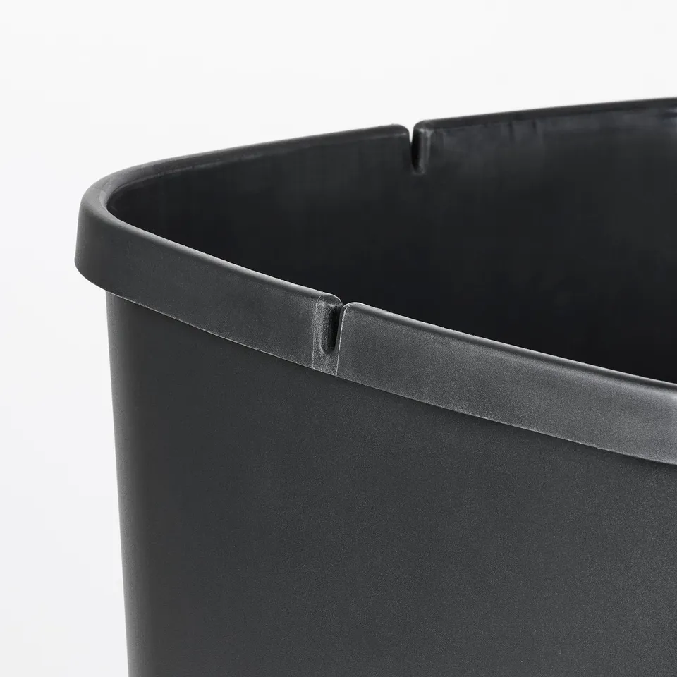 Black plastic bin with smooth, rounded edges and lid for waste management. Designed for easy cleaning and to hold bags securely.