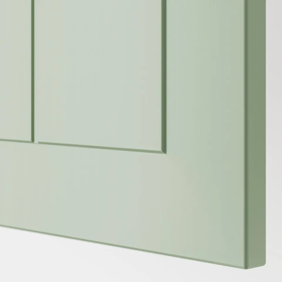 A close-up of a green kitchen cabinet, showcasing smooth, high-quality paint and sturdy materials.