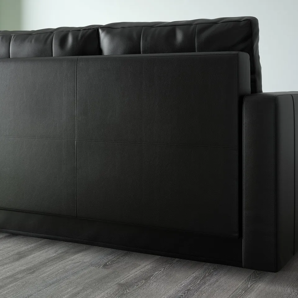 Black leather sectional sofa with built-in storage, converting into a bed.