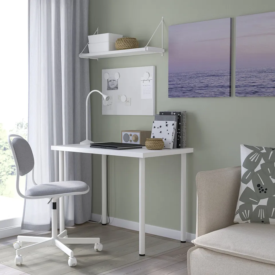 Corner LINNMON desk with lamp, books. Minimalist design.