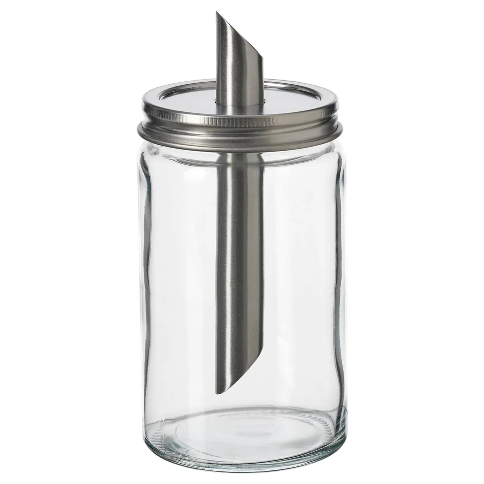 An empty, transparent glass sugar shaker with a stainless steel lid and a metal inner tube, designed by IKEA.