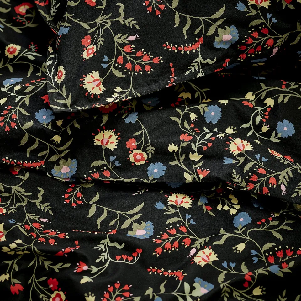 Floral duvet cover in deep black with vivid wildflowers. High-quality organic cotton, soft and detailed.
