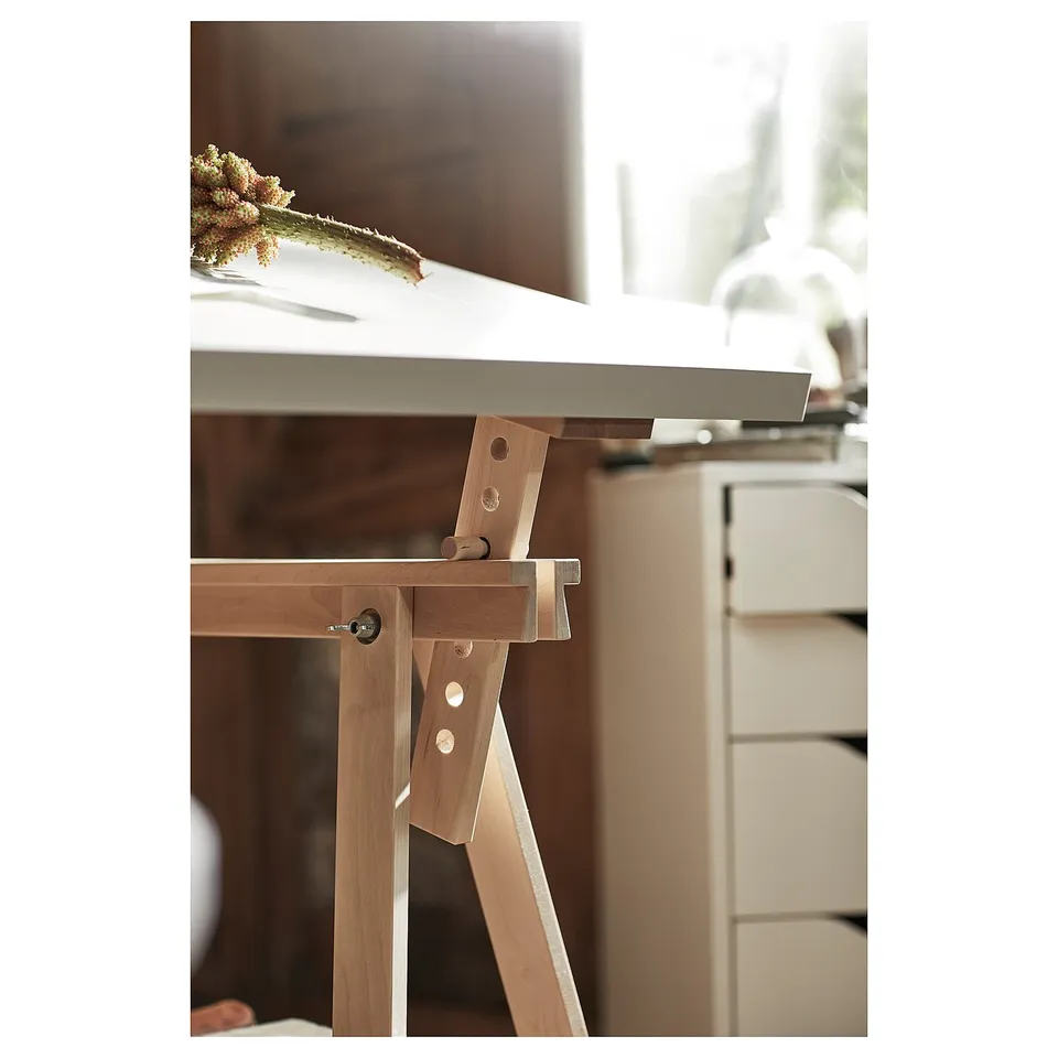 LAGKAPTEN table base in wood shown, part of sustainable furniture series. Highlighting trestle design with metal fittings for table stability.