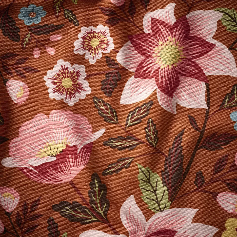 Floral-patterned fabric, warm brown background, pink and red flowers, and green leaves. Detailed and vibrant.