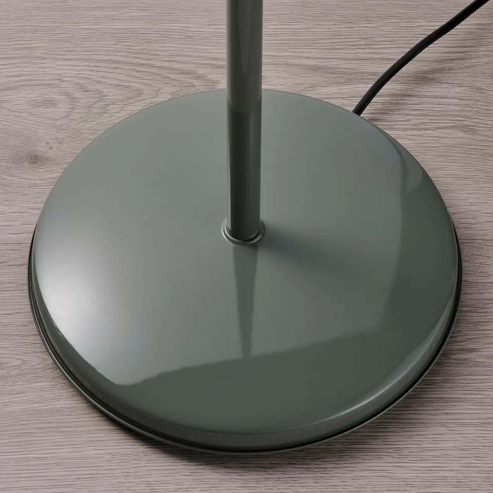 Large, sleek floor lamp base made of smooth, sturdy material, likely steel, with glossy finish on wooden surface.