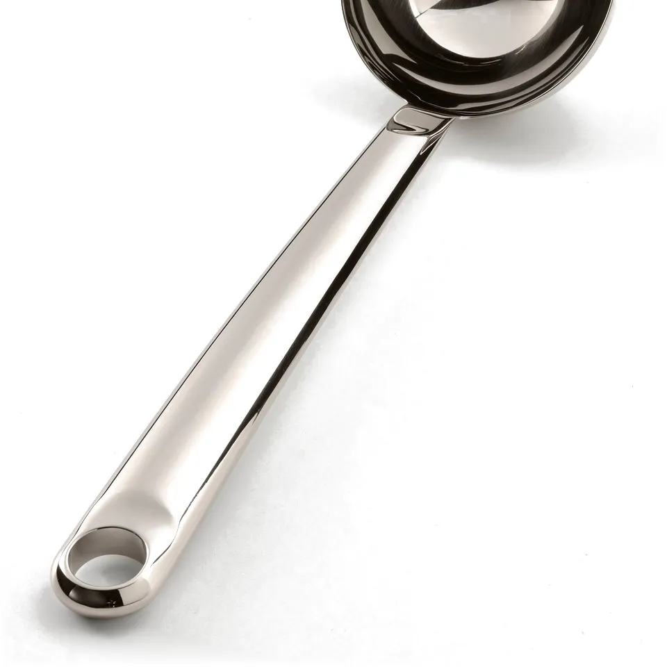 Stainless steel soup ladle with curved handle and hanging hole, lying on a white surface.