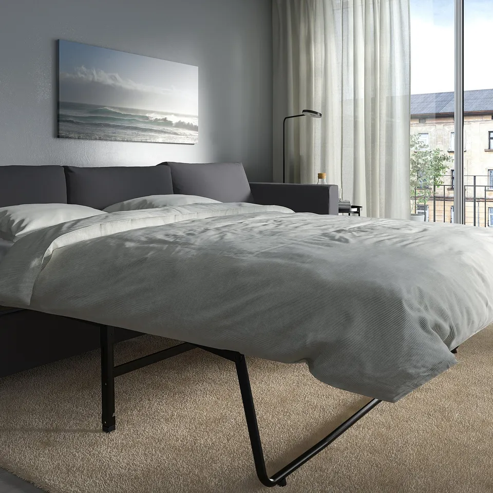 Modern bedroom with a VIMLE sofa-bed, ocean wall art.