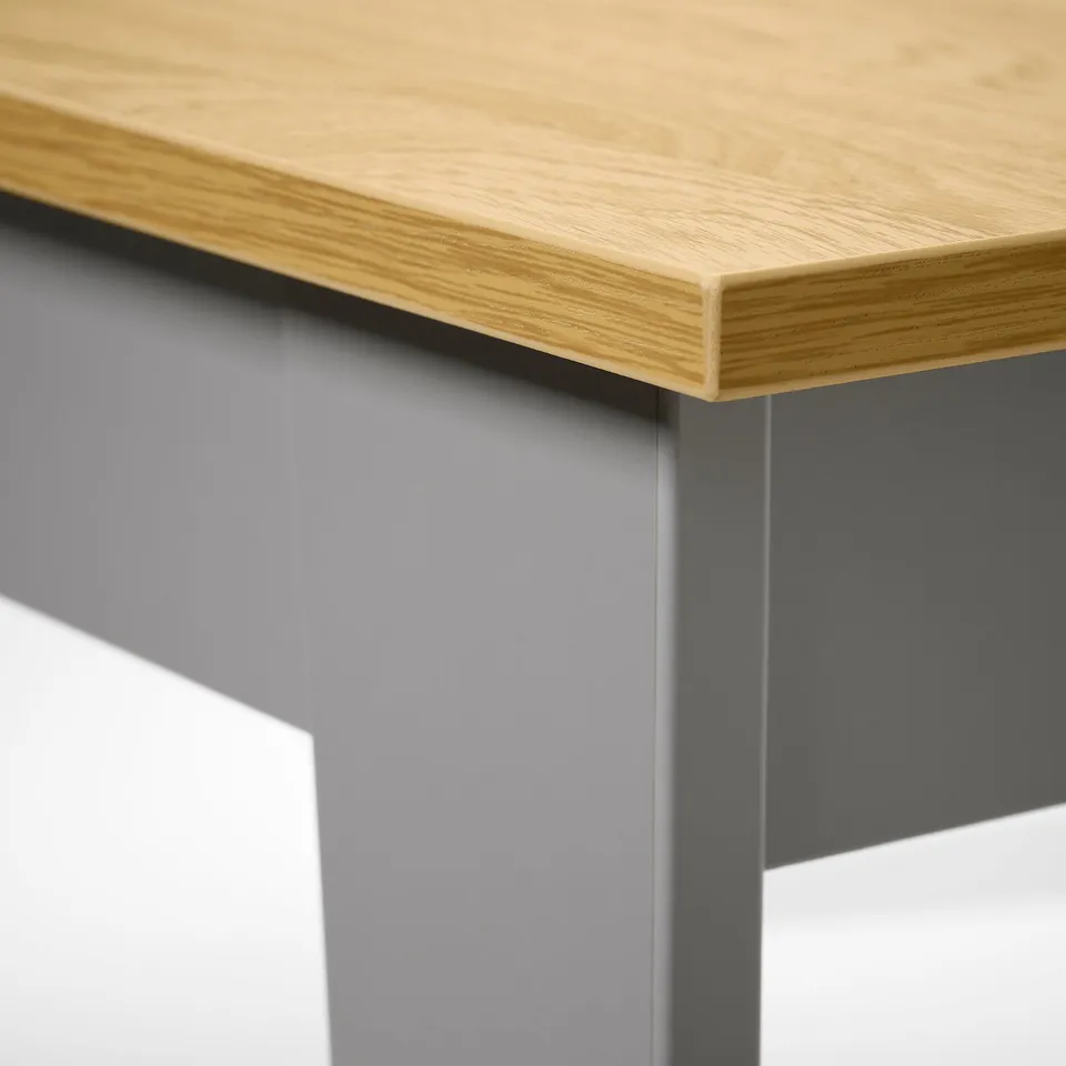 Close-up of well-crafted wooden tabletop with smooth grain, supported by sturdy metal legs.