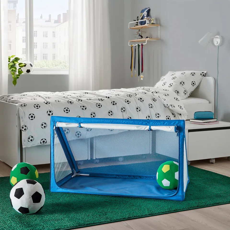 Childs room with SPORTSLIG ball storage, football prints on bed.