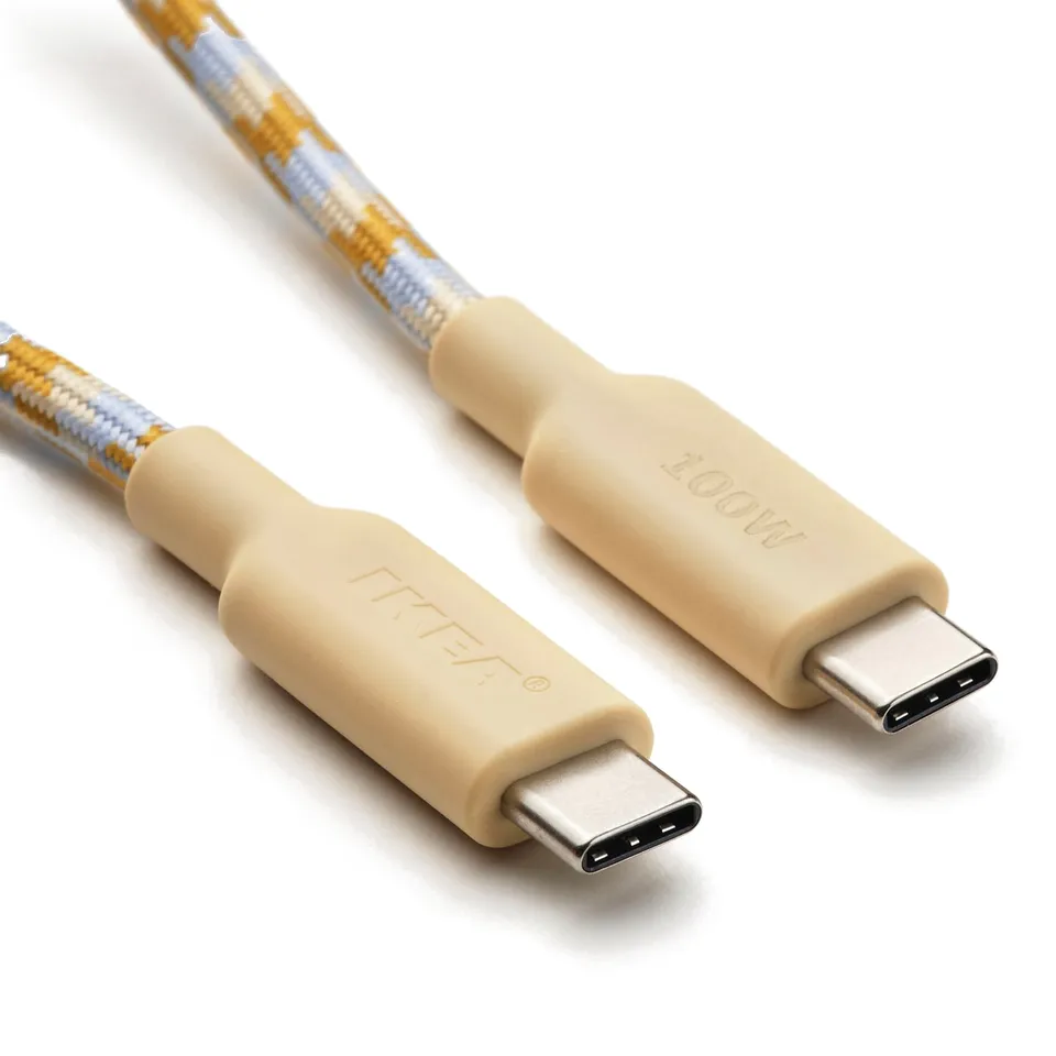 Two usb-c cables with beige connectors and braided blue and gold design lie side by side, showcasing their durable, textured design.