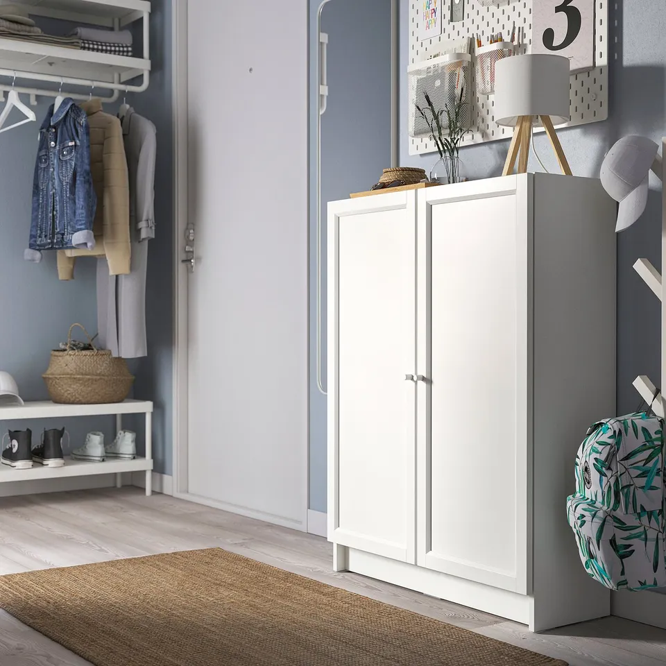 Organised entryway with BILLY white cabinet, wooden floor, hanging coats, and storage shelves.