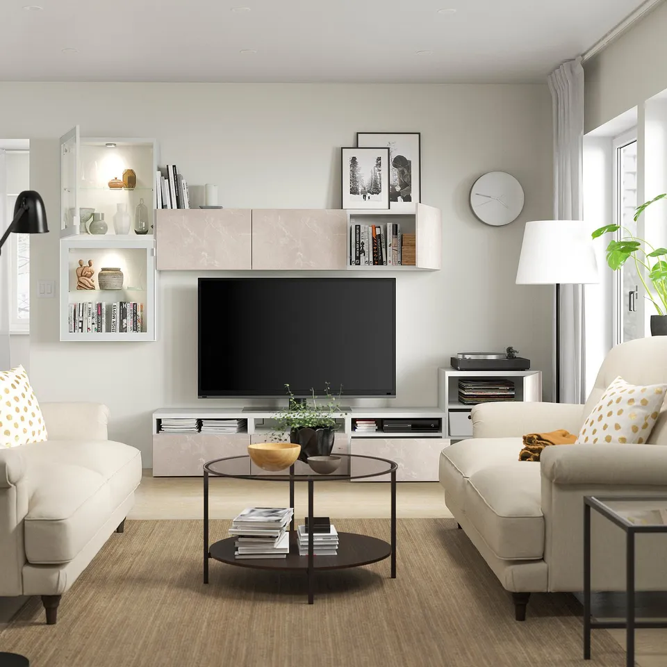 Modern living room with light furniture. Tv unit has adjustable shelves and cable management. Sofas with pillows.