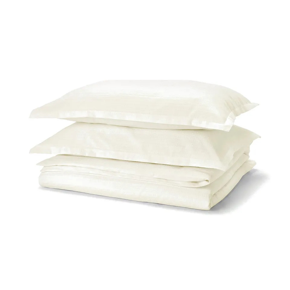 Stack of white LUKTVICKER duvet covers, featuring waffle weave, folded neatly.