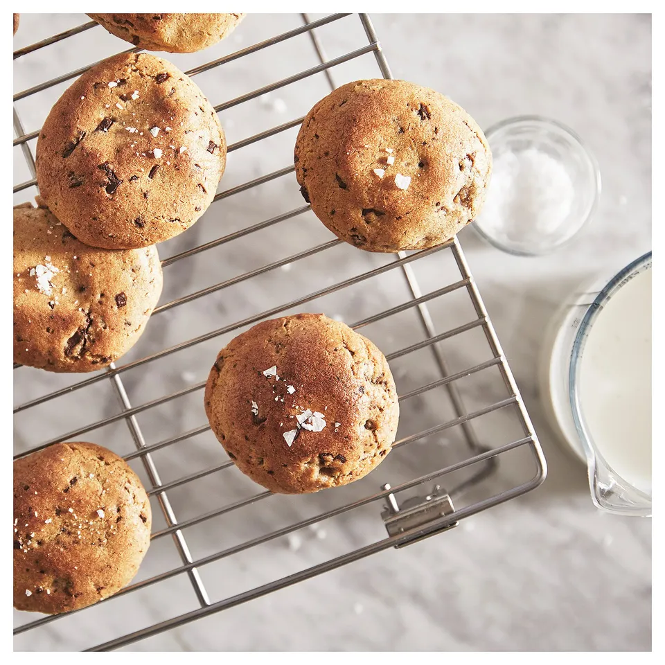 Freshly baked cookies cooling on a metallic rack.