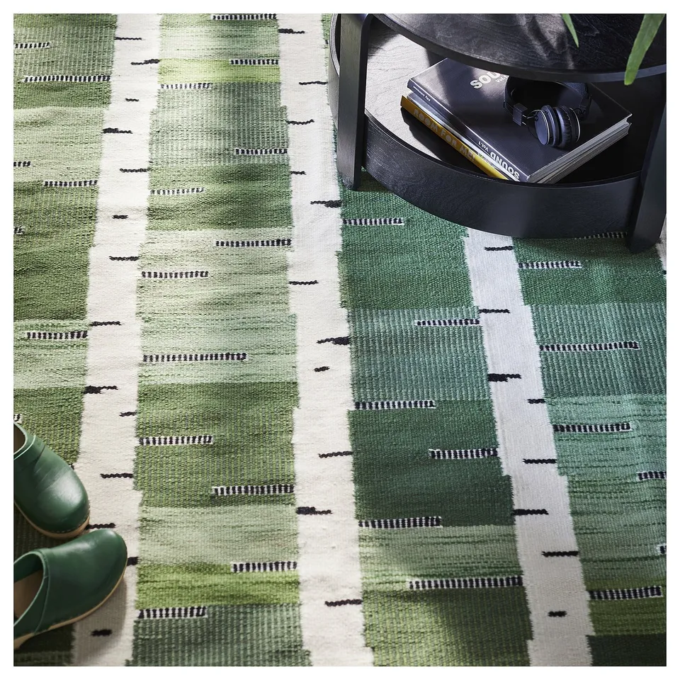 Green and white woven rug with birch tree pattern, handcrafted, reversible, cotton and wool, rectangular.