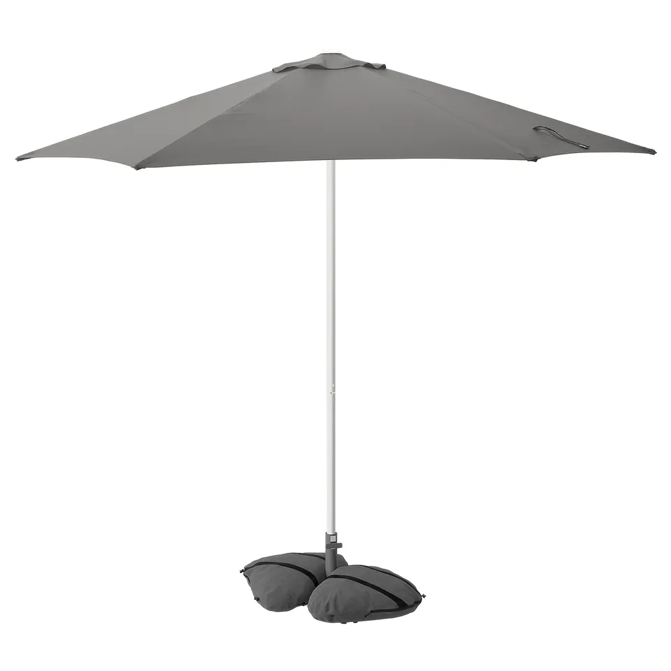 A grey HÖGÖN parasol with a white pole, offering sun protection, and a sandbag base.