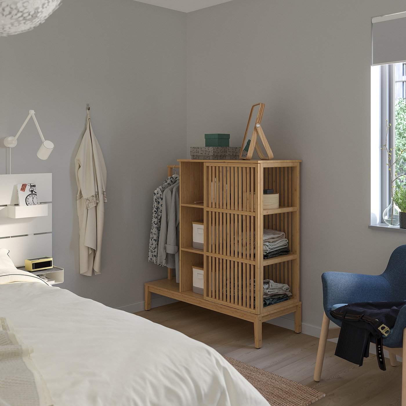 Modern bedroom with grey walls, light wood floor. Bamboo wardrobe, blue chair, white bed.