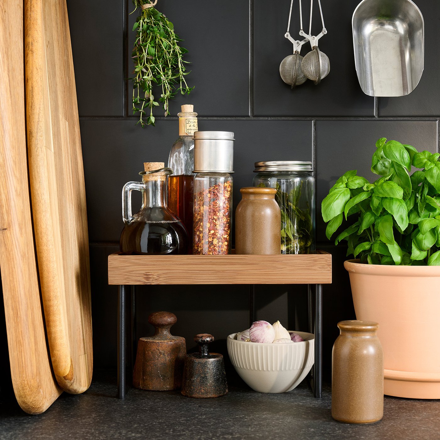 Kitchen organiser with jars, spices, and chopping boards on tabletops.