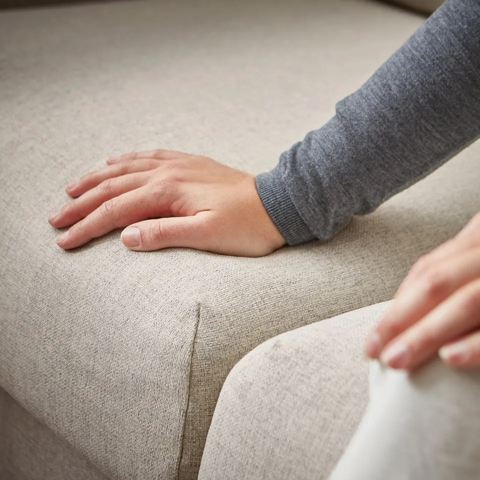 Person sitting on VIMLE sofa, light grey, minimalist design.