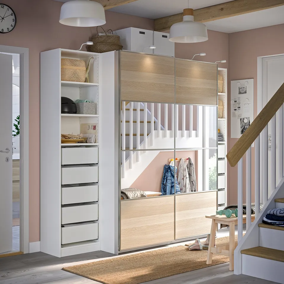Well-organized modern closet with sliding doors and drawers. Wood and glass panels, hanging space, shelves, and proper lighting.