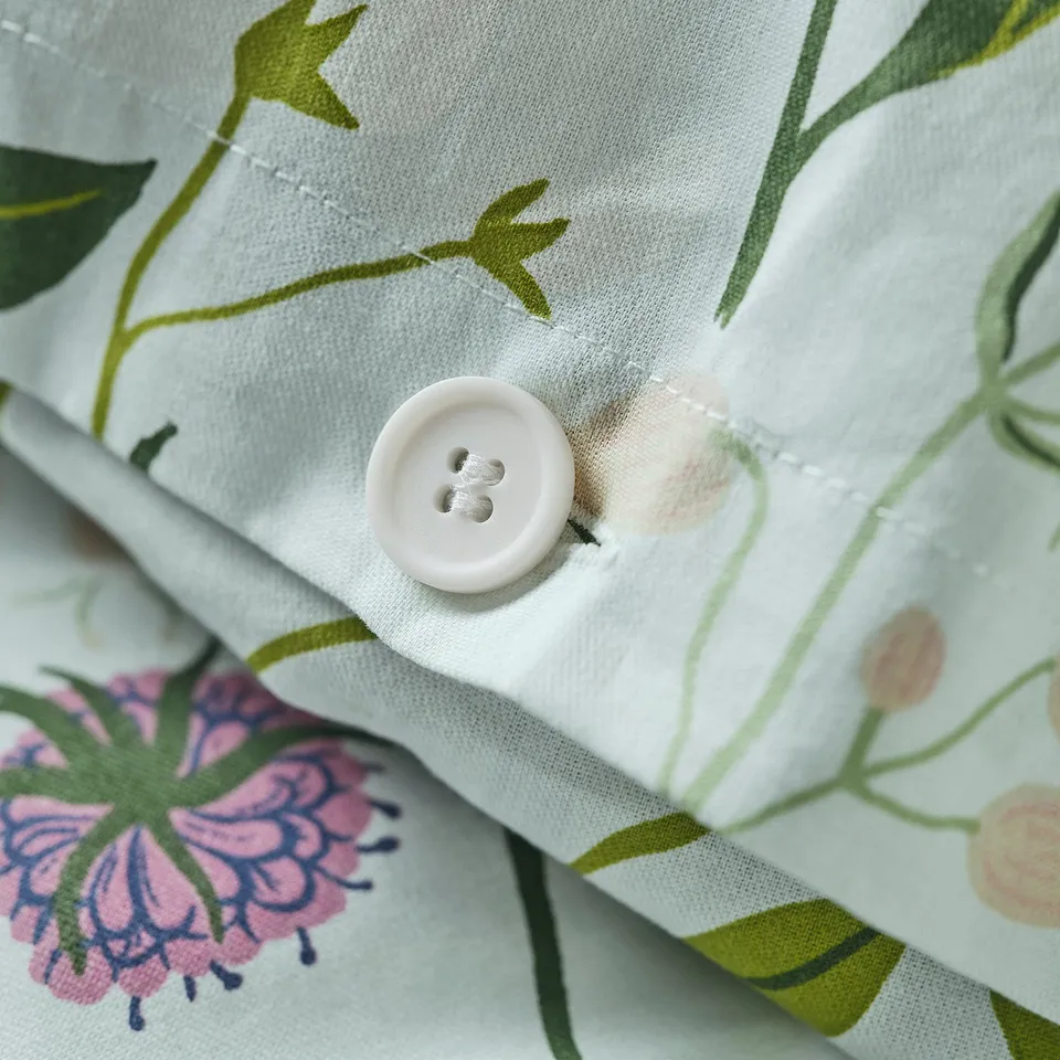 Close-up of a MATTOXBÄR duvet with button closure, showcasing its floral design.