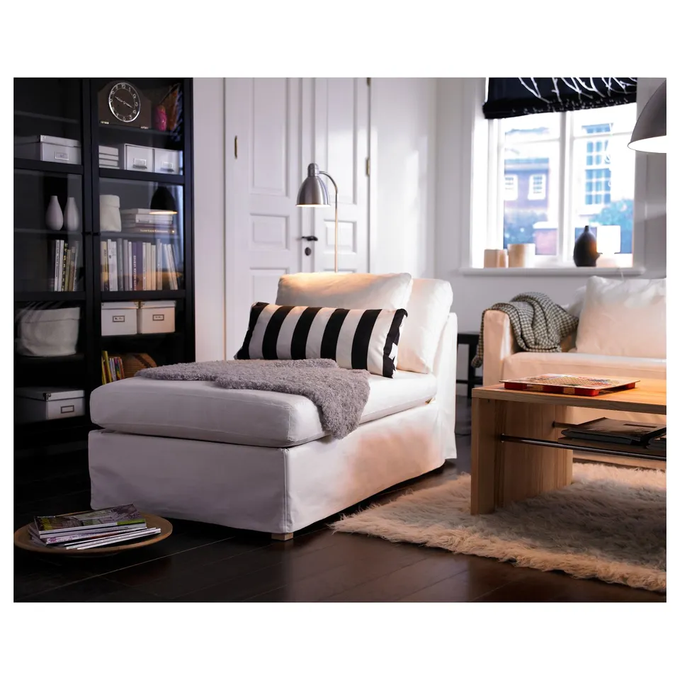 Modern living room with white LERSTA floor lamp, black and white pillows, coffee table, bookshelf, and fluffy rug.