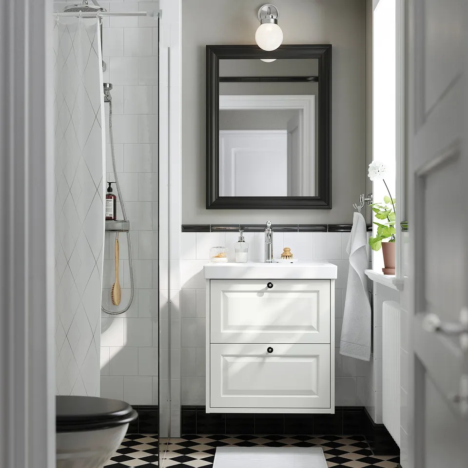 White TÄNNFORSEN bathroom vanity with drawers, classic design, wall-mounted with basin, mirror, shower, plant.
