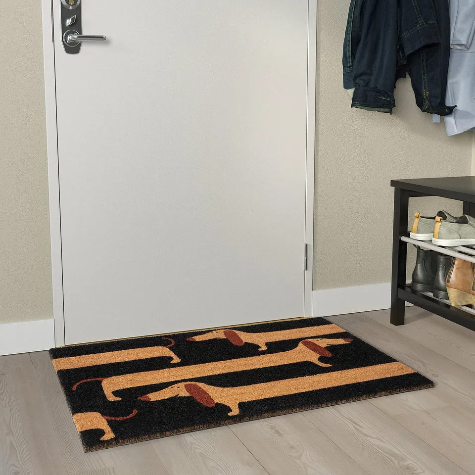Playful dachshund doormat at entryway with shoe rack and jackets.