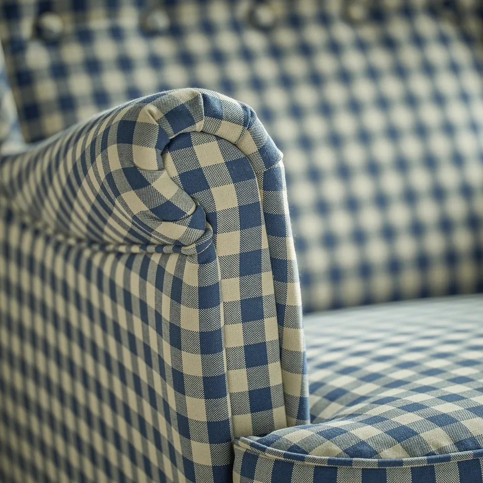Close-up of a patterned upholstered chair in shades of grey and blue, showcasing its high-quality fabric and detailed stitching.