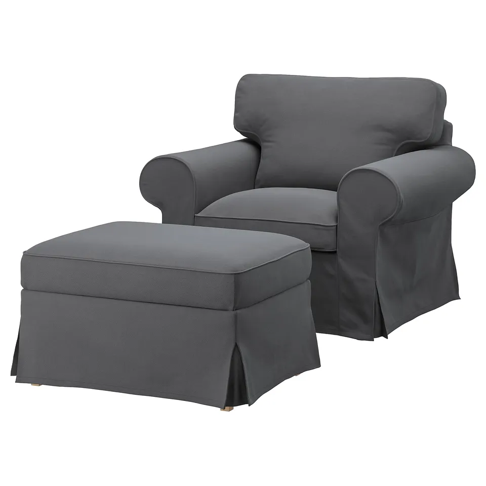A grey EKTORP armchair with a matching ottoman. It a classic design with rolled arms and thick cushions. The set is upholstered in a fabric cover.