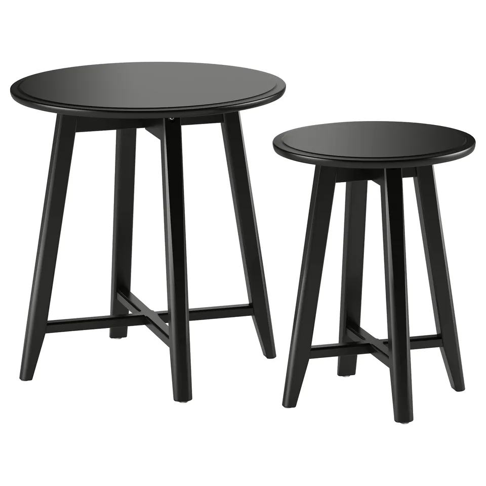 Image two black round nesting tables with sleek legs, modern design.