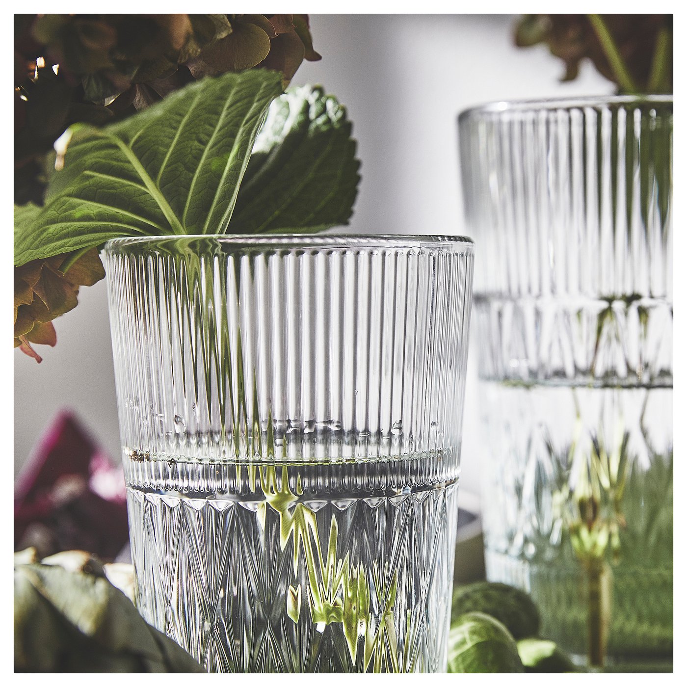 Elegant glass vases, SMÄLLSPIREA series, clear, fluted design, holding greenery.