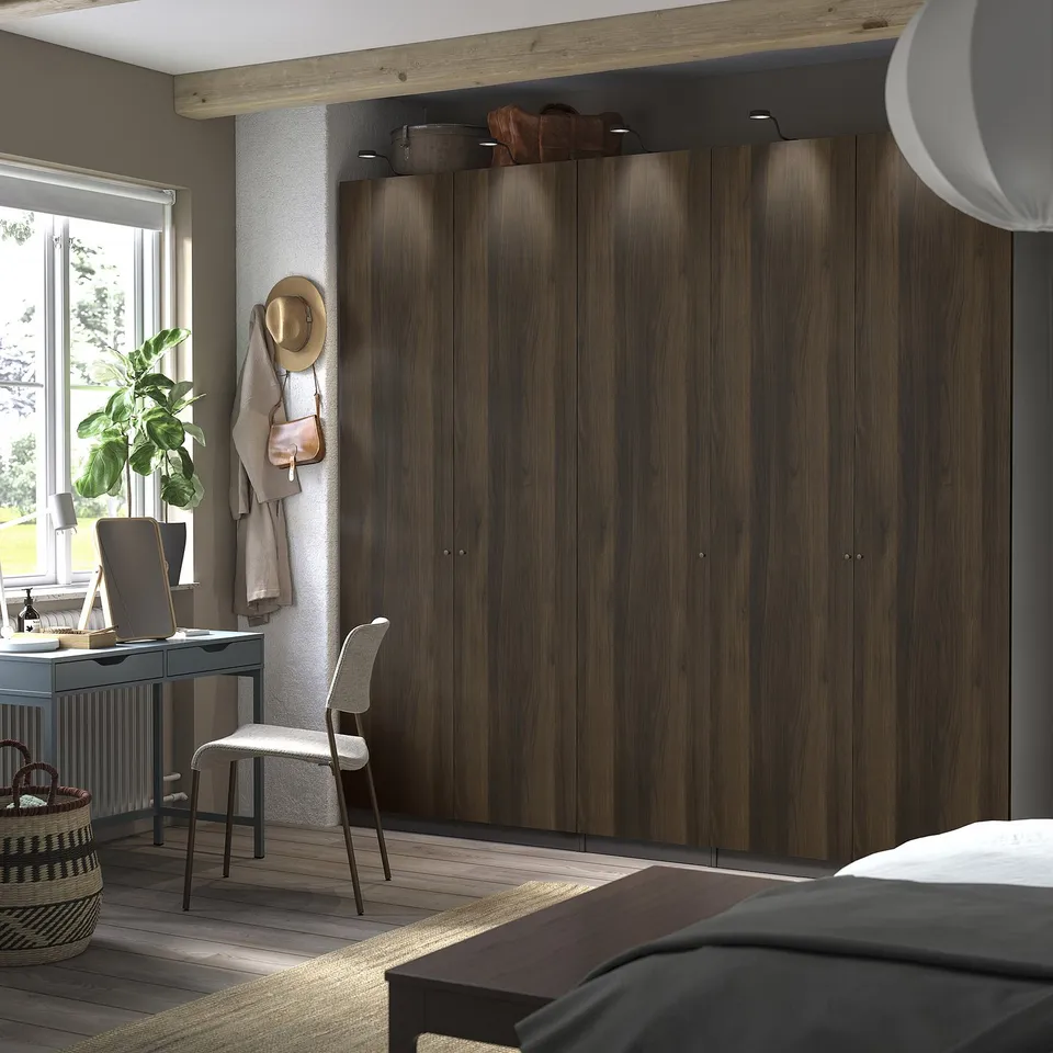 Modern bedroom with large dark brown PAX wardrobe, window, and home office.