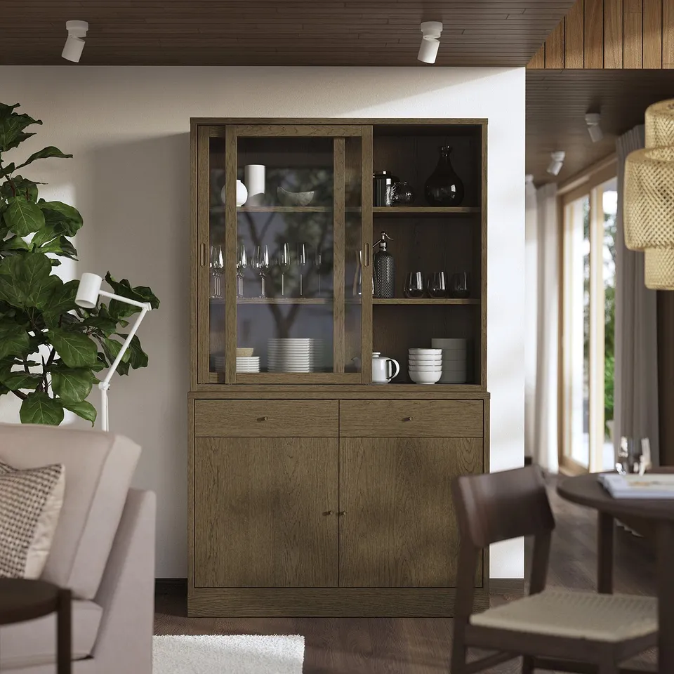 Wooden TONSTAD sideboard with glass cabinet, displaying dishes, positioned between dining chairs.