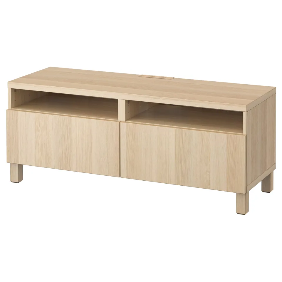 The BESTÅ tv bench is a light wood-colored, rectangular unit with two doors, a centre open shelf, and adjustable shelving for cable management.