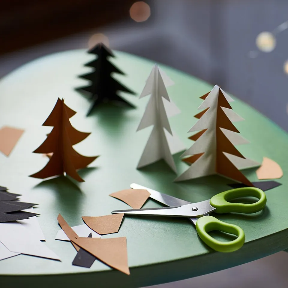 Paper crafts with safe green scissors on green board.