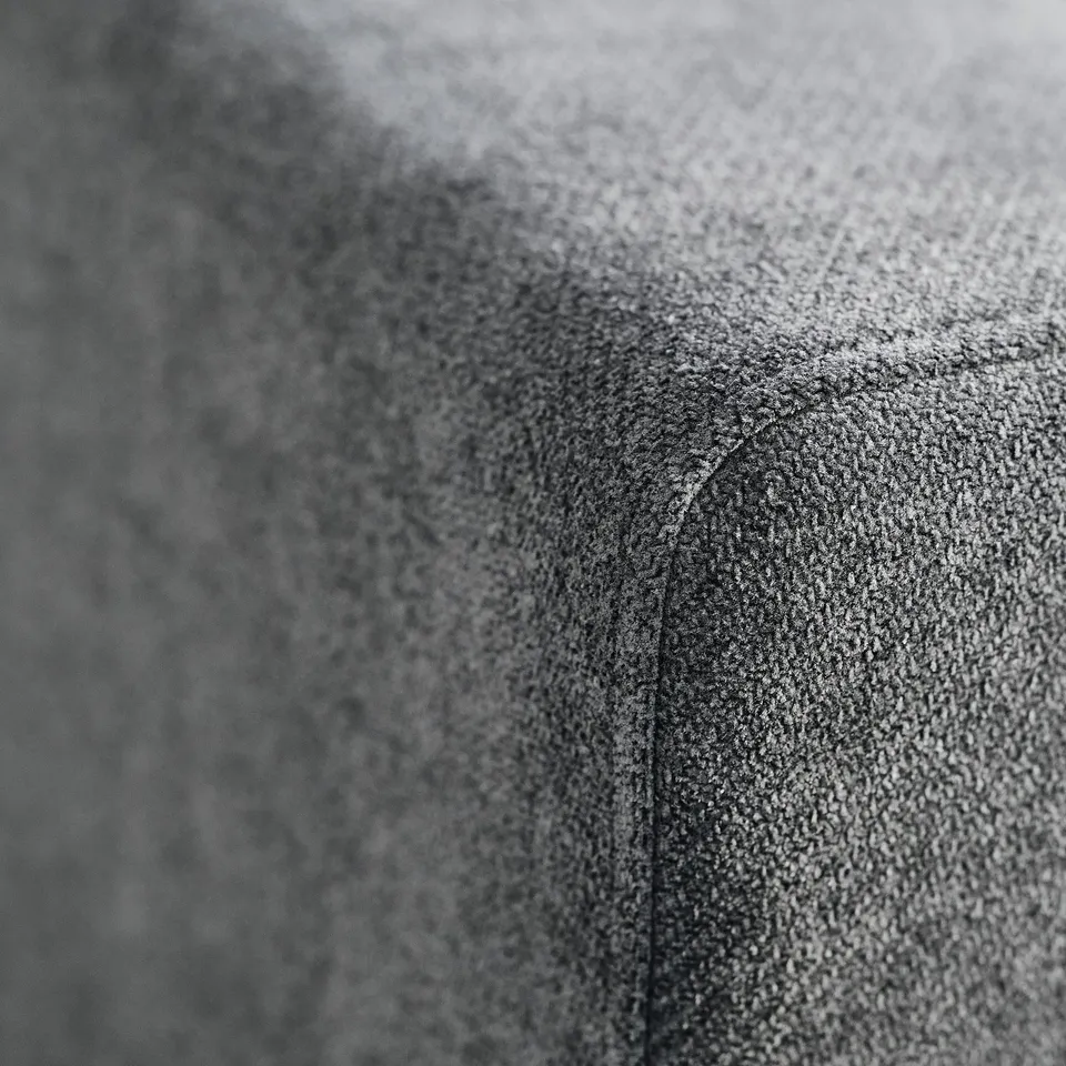 Close-up of soft, textured grey fabric, showcasing its subtle sheen and durable weave, indicative of high-quality, recycled materials.