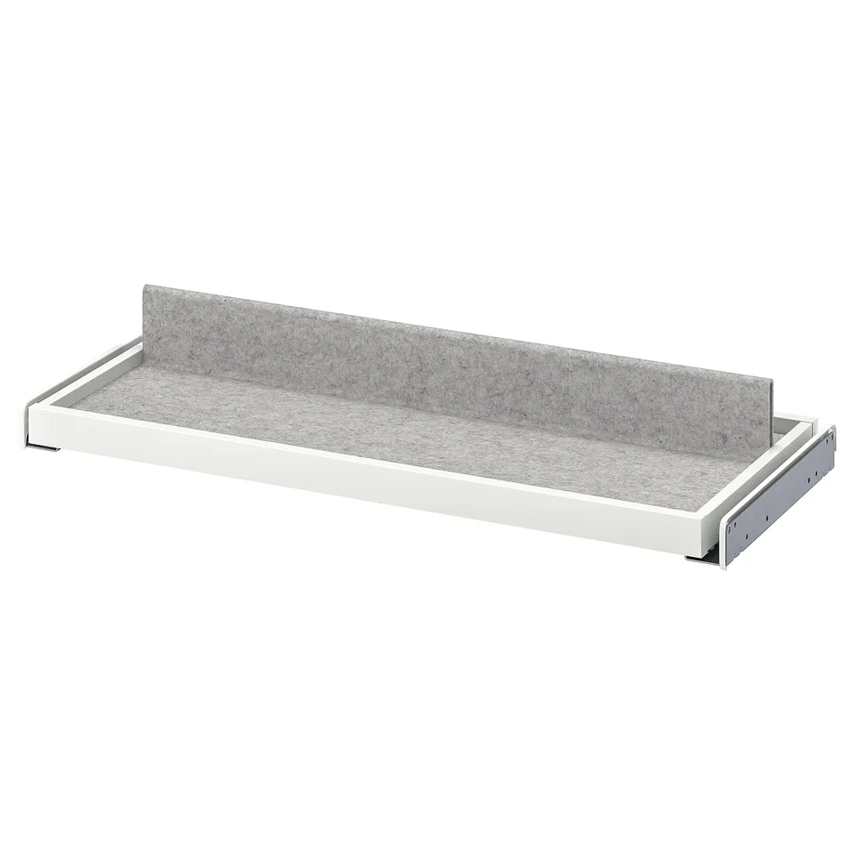 A white KOMPLEMENT pull-out tray with grey felt liner, designed for organising wardrobe items.