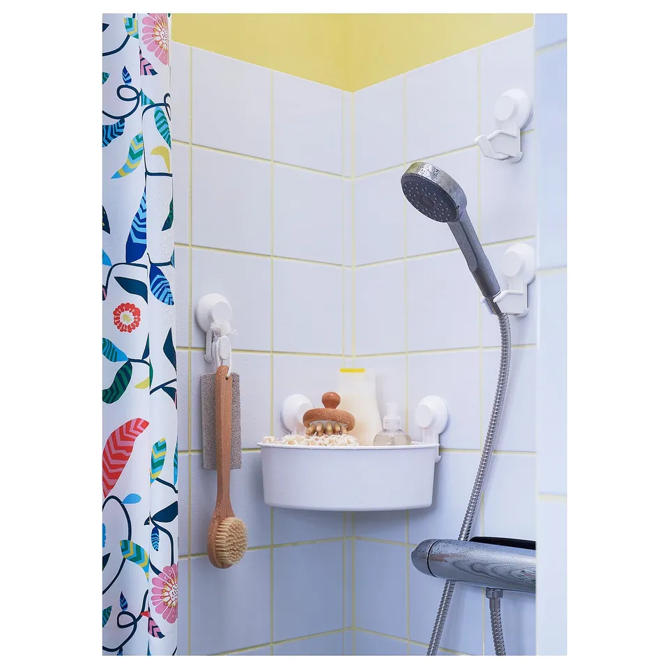 Colourful bathroom with patterned shower curtain and hooks holding toiletries.