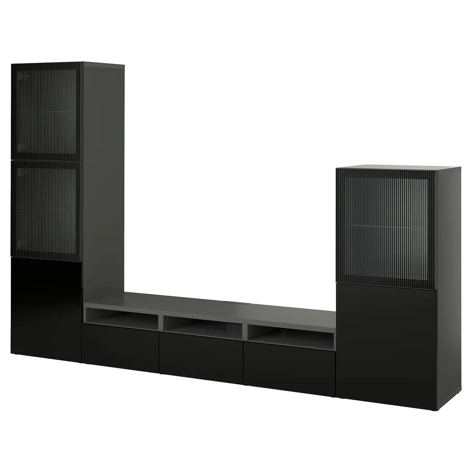 Black IKEA BESTÅ tv unit with modern design, long bench, drawers, shelves, and tall glass-door cabinets.