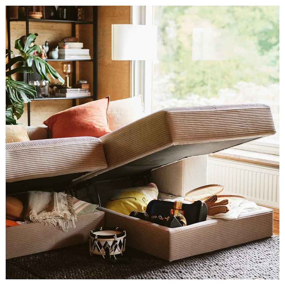 Beige JÄTTEBO sofa with hidden storage, books, and plants.