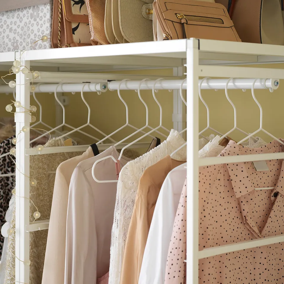 White JONAXEL storage system with clothes and handbags.
