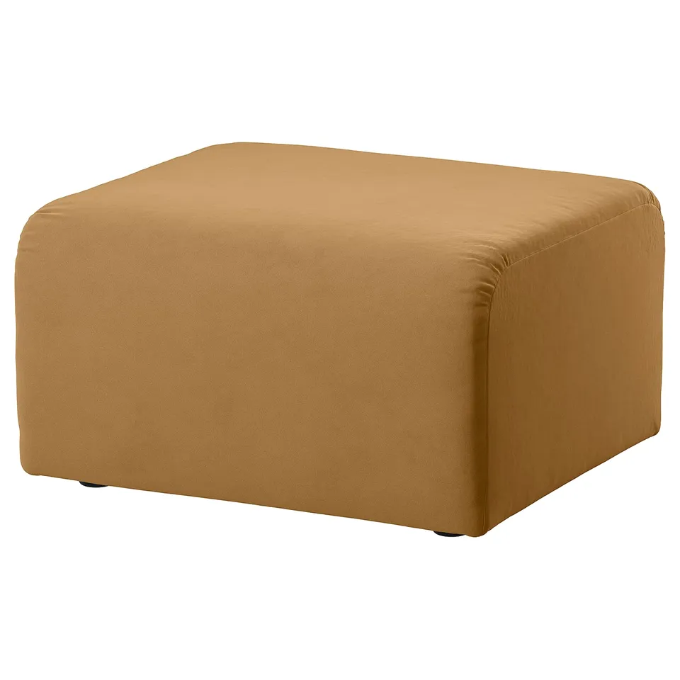 A brown STOCKHOLM 2025 ottoman. It has a square shape and velvet material with a soft, reflective sheen.