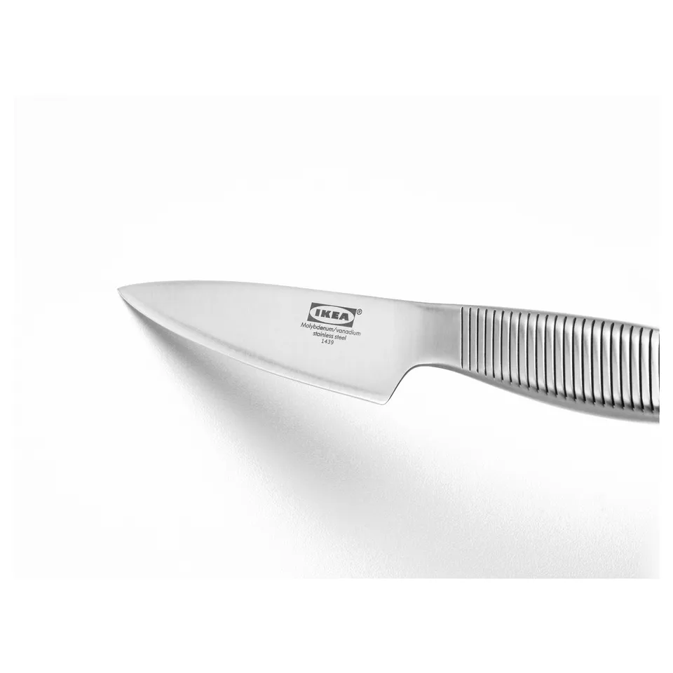 IKEA 365+ kitchen knife on plain surface. Stainless steel blade and handle, designed for durability with grooved grip.