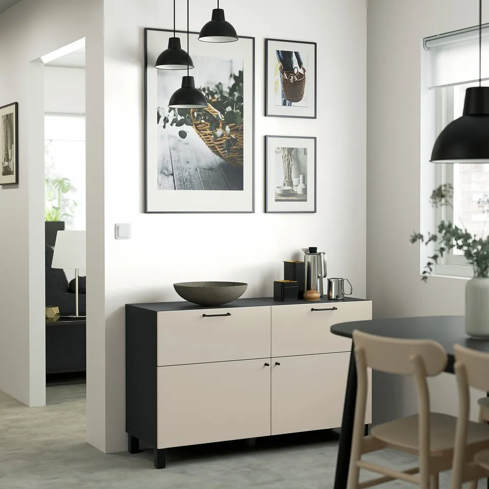A modern white & black BESTÅ sideboard with drawers & shelves. Hangs art above. Large enough to hold dishes & decor near dining chairs.