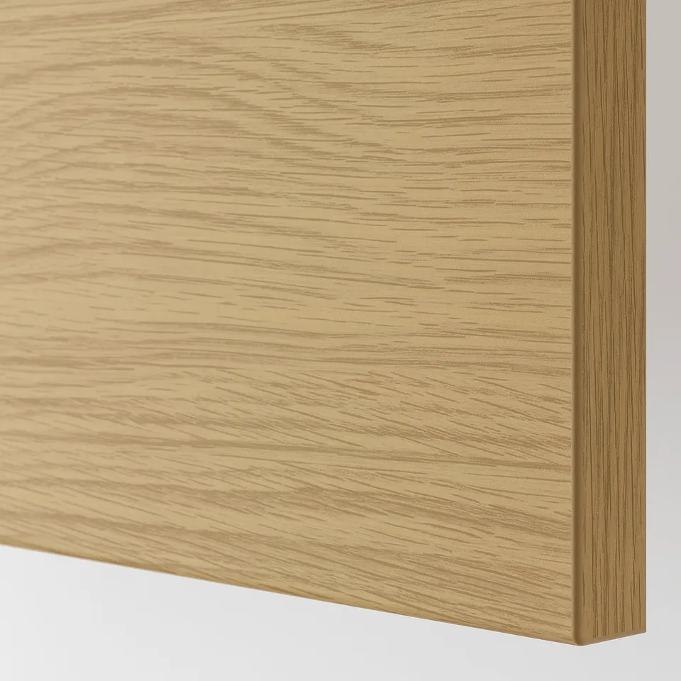 Close-up of sleek, light oak kitchen cabinet. Smooth finish, showing fine wood grain detail.