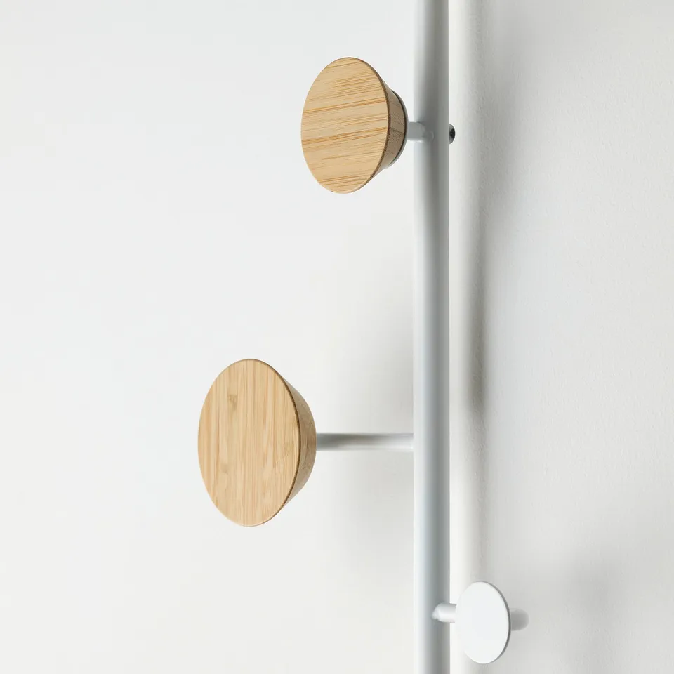 Two wooden knobs on metal rail, mounted on door. Simple, sturdy design.