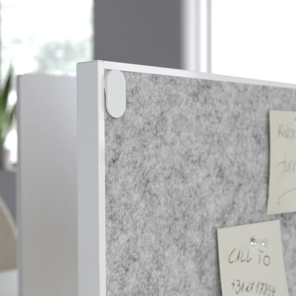 A dual-sided pin and whiteboard mounted on a TROTTEN office divider, displaying notes.